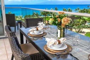 Elegant oceanside dining with wine, flowers, sunshine, and tropical views.