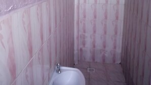 A small bathroom with a shower, a toilet, and a sink. - Sweet Banana House (Lamu)