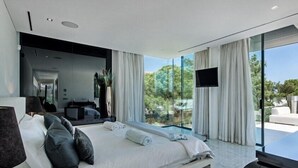 Une chambre d’hôtel moderne avec un grand lit, un bureau et une télévision.