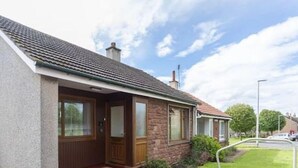 A single-story house with a brick facade, a tiled roof, and a front porch.