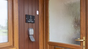 A wooden door with a frosted glass panel, a doorbell, and a sign indicating room number 1.