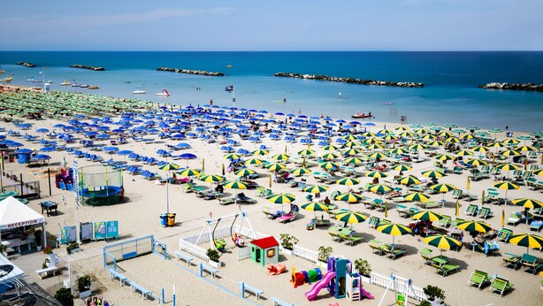 A beach with numerous umbrellas and sun loungers, a reception area, and a playground. - Hotel Villa Sole (Bellaria-Igea Marina)