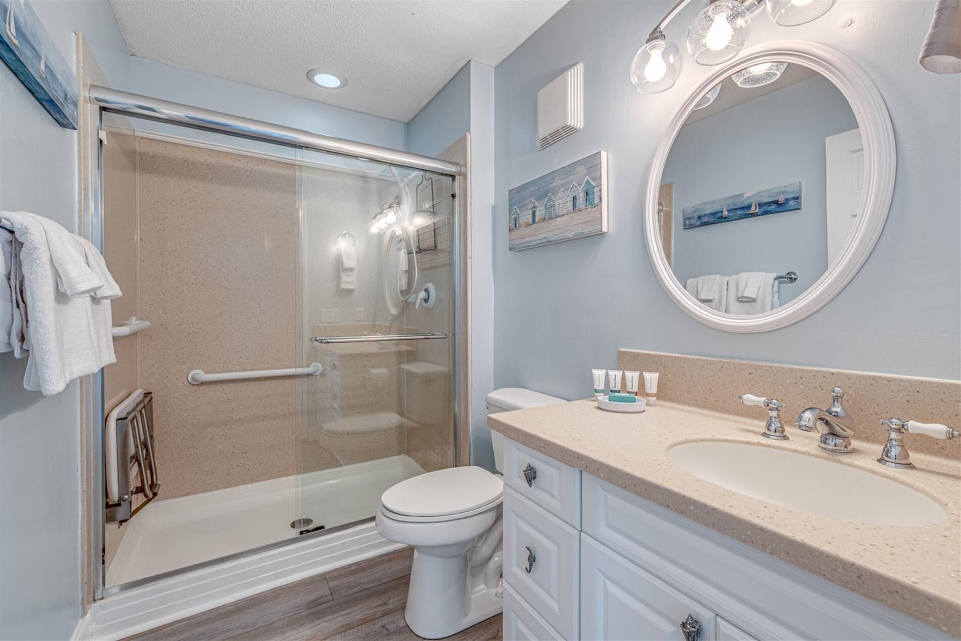 Une salle de bain avec une douche à parois de verre, des toilettes, un meuble-lavabo et un grand miroir.