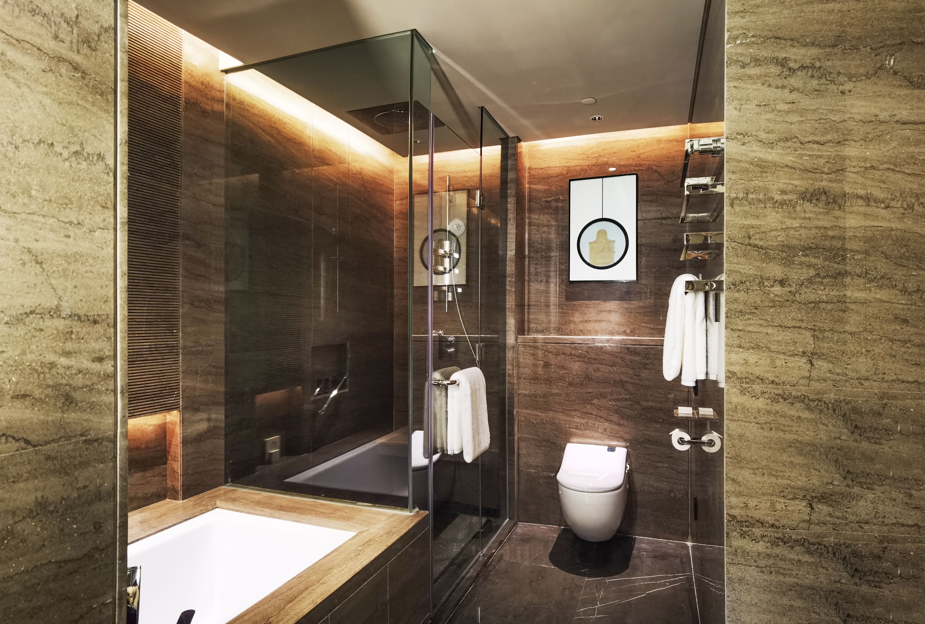 A modern bathroom with a glass-enclosed shower, a standalone bathtub, and a toilet.