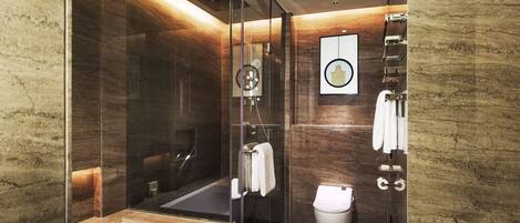 A modern bathroom with a glass-enclosed shower, a standalone bathtub, and a toilet.