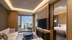 A modern hotel room with a sofa, a round table, a TV, and a bed. - Kempinski Residences Guangzhou (Guangzhou)