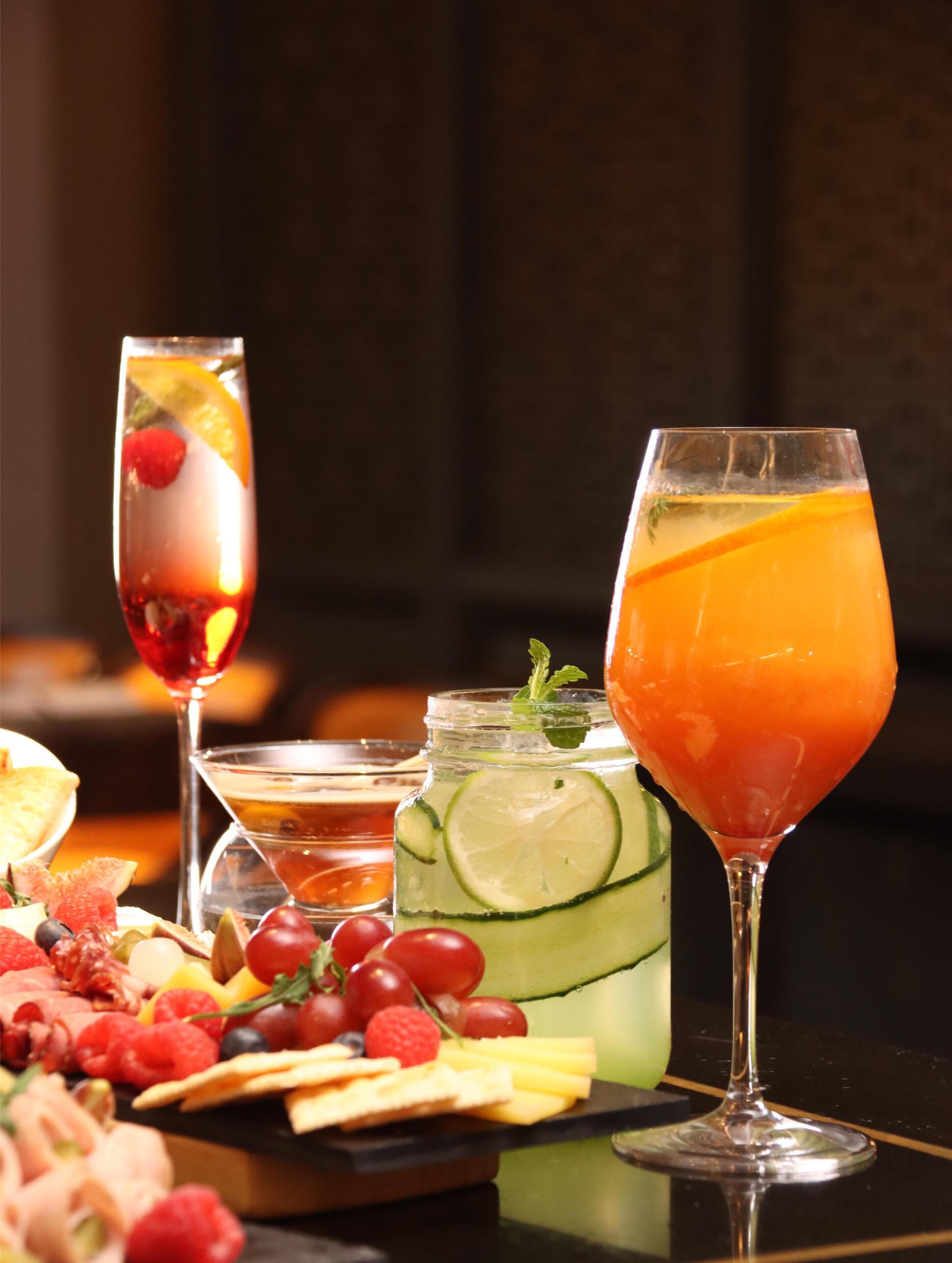 A table with various drinks and a fruit platter.
