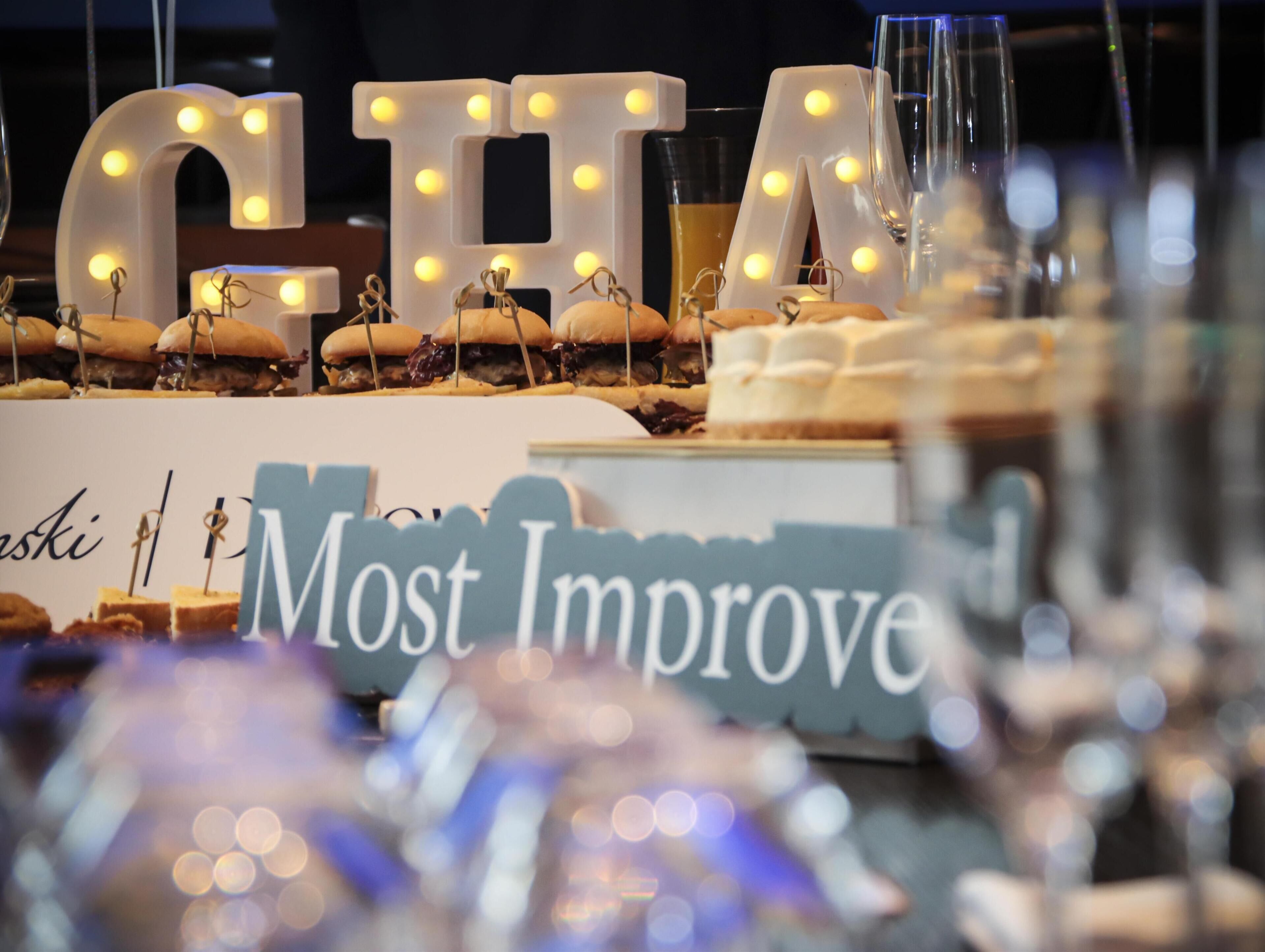 Illuminated letters spelling "CHEF" with food items on display.