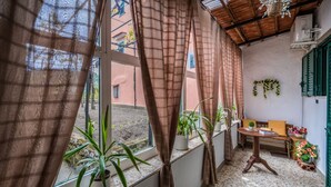 Una habitación acogedora con ventana, plantas en macetas, una mesa de madera y un banco.