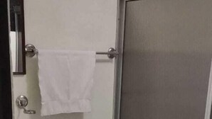 Un baño pequeño con inodoro, lavamanos y ducha.