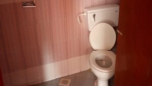 A small, compact bathroom with a toilet, a window, and a vent. - Inns Lodge (Naivasha)