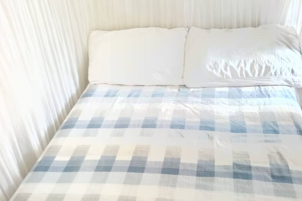 A bed with a checkered bedspread and two pillows.
