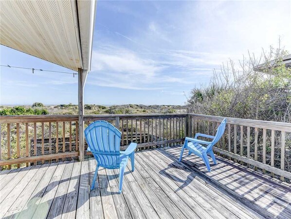 A wooden deck with two blue chairs and a covered area. - Pounds Cottage, 1 Bedroom, Ocean Front, Pet Friendly, Sleeps 5 (St. Augustine)