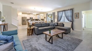 A modern living room with a grey sectional sofa, a wooden coffee table, and a grey shag rug. - Perfect Family Getaway! Ultimate WATERPARK Resort Near Disney! (Davenport)