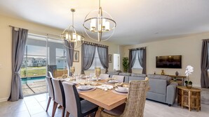 A dining area with a wooden table set for six, surrounded by wicker chairs. - Perfect Family Getaway! Ultimate WATERPARK Resort Near Disney! (Davenport)