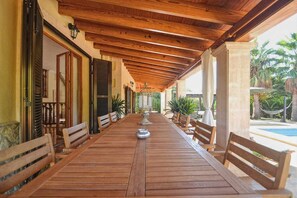 Enjoy meals al fresco in this charming outdoor dining area, surrounded by lush greenery and a glimpse of the pool.