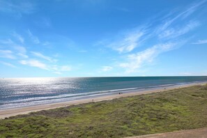 A beach with a clear sky and a road leading to the shore.