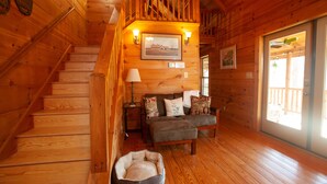 Un intérieur en bois avec un escalier, un canapé et un panier pour chien.
