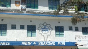 A building with a sign for "New 4 Seasons Pub" and a "No Added Sugar" logo. - Four Seasons Lodge (Naivasha)
