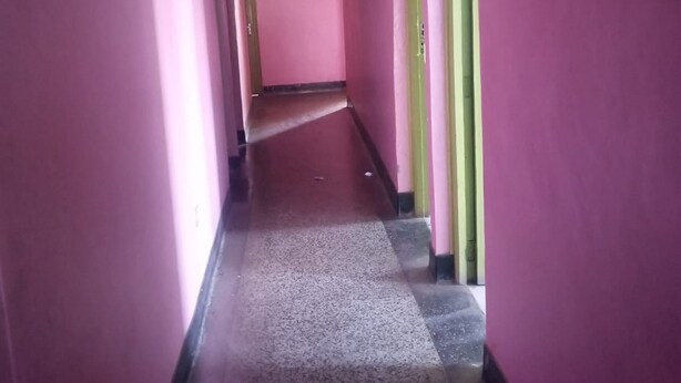 A corridor with pink walls and a carpeted floor. - Four Seasons Lodge (Naivasha)