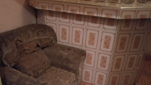 A corner of a room with a patterned carpet, a patterned sofa, and a tiled backsplash. - Four Seasons Lodge (Naivasha)