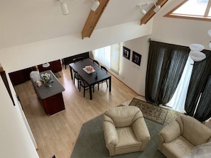 Un amplio espacio de sala con una mesa de comedor y sillas, una cocina con mostrador y armarios, y una zona de estar con dos sofás.