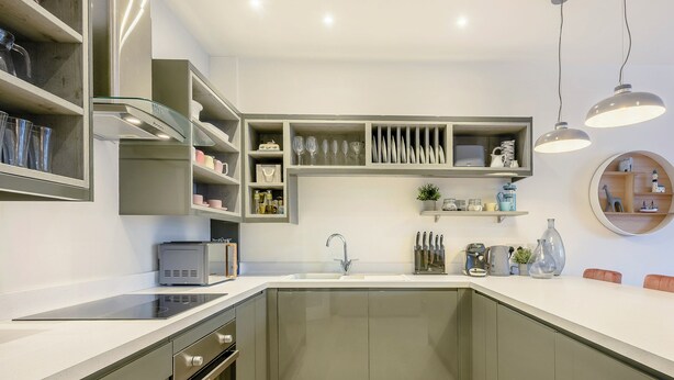 A modern kitchen with built-in appliances, a central island, and a round shelf with decorative items. - 2 bedroom accommodation in Mundesley, near North Walsham (Mundesley, near North Walsham)