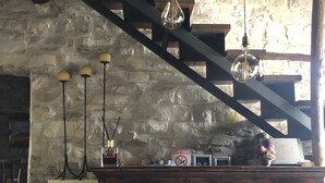A rustic wooden counter with a stone wall backdrop, a large clay pot, and a sign indicating a no smoking area. - Cascina Bertolotto Wine Resort. (Spigno Monferrato)