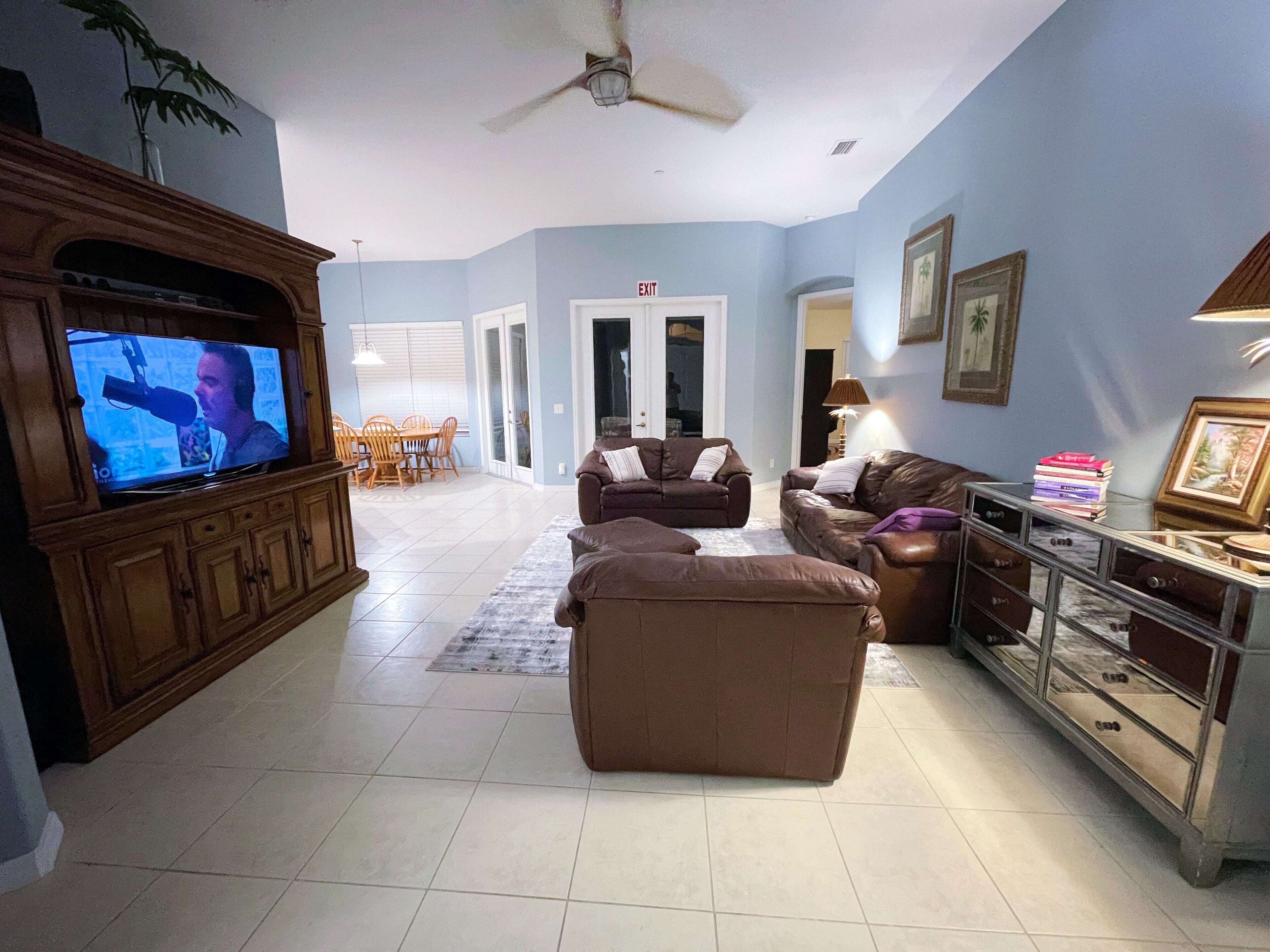 Una sala de estar con televisión, dos sofás, una mesa de centro y un aparador.