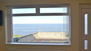 A room with a large window overlooking the sea. - Dolphin View - UK30689 (Portknockie)