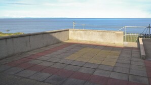 A terrace with a view of the sea, featuring a concrete wall and tiled flooring. - Dolphin View - UK30689 (Portknockie)