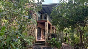 A two-story building with a balcony, surrounded by dense foliage. - Avalon in Arcadia Magnetic Island (Arcadia)