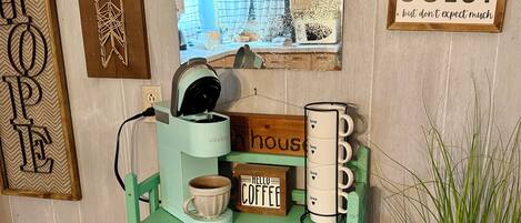 A coffee station with a sign that reads 'HELLO COFFEE' and a 'BE OUR GUEST' sign.