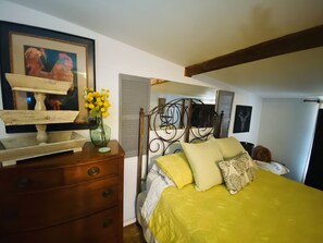 A bedroom with a bed, dresser, and a framed picture on the wall. - Cottage with Hot Tub & Pool in Texas Hill Country  (Bandera)