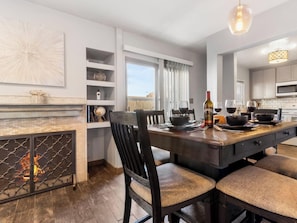 Una cocina moderna con comedor, chimenea y vistas al exterior.