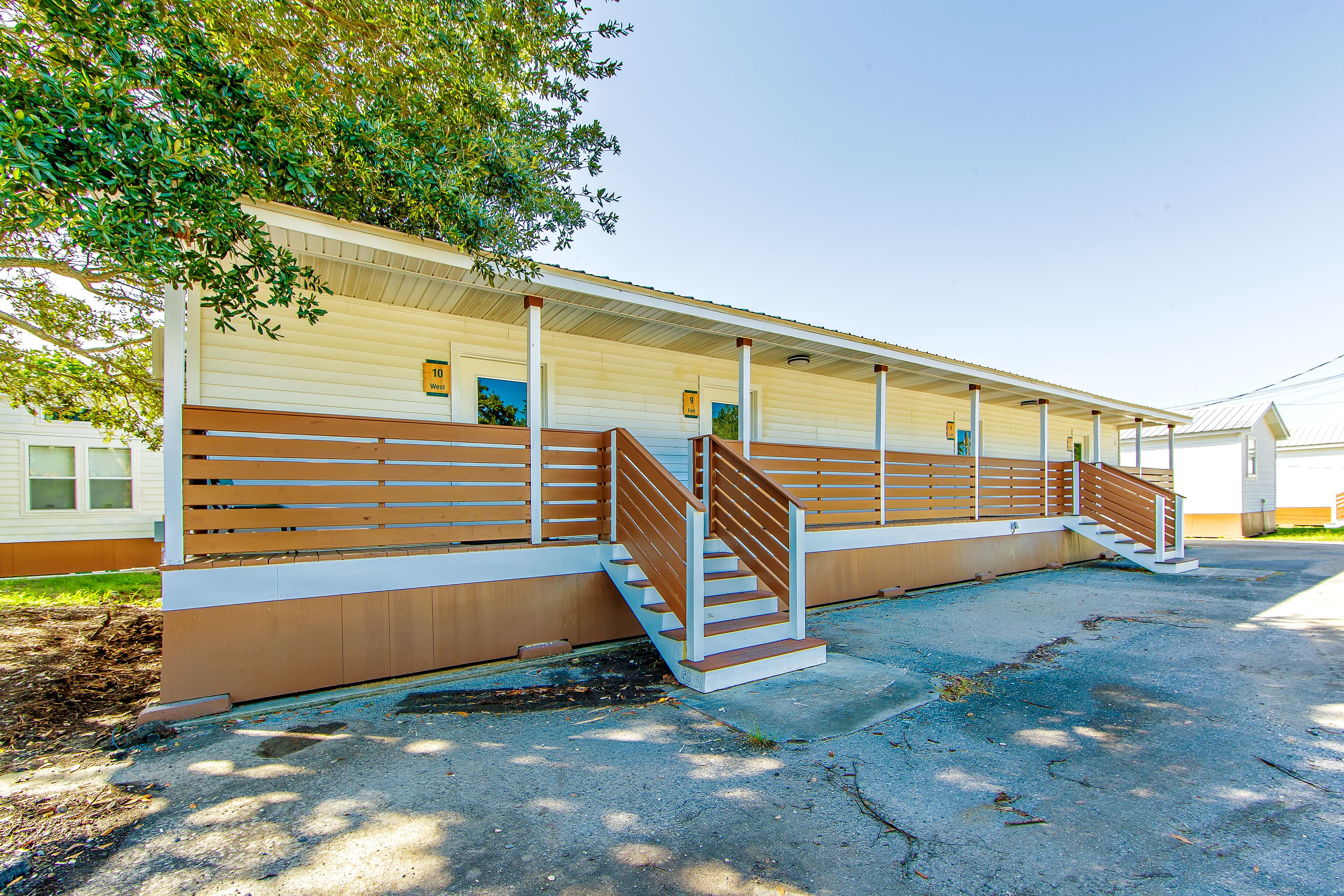 A motel with a covered walkway and a staircase leading to the entrance.