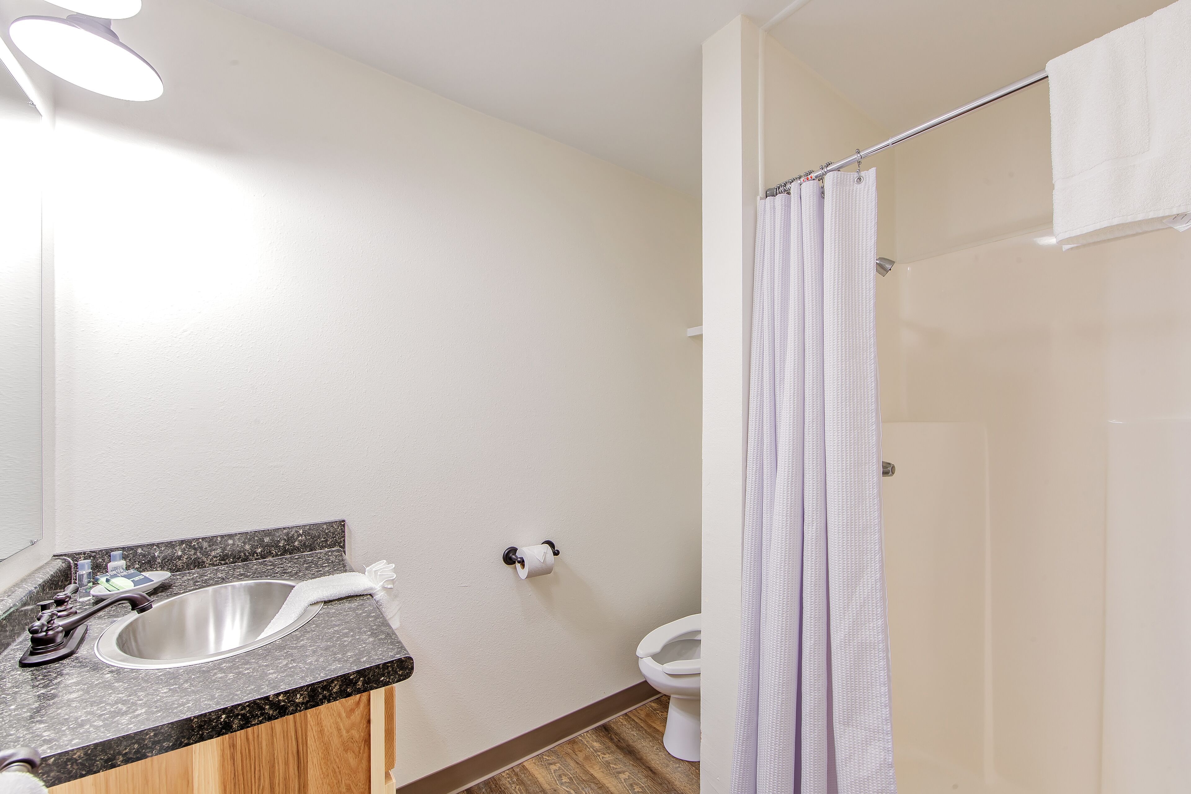 Un baño con lavamanos, inodoro y cortina de ducha.