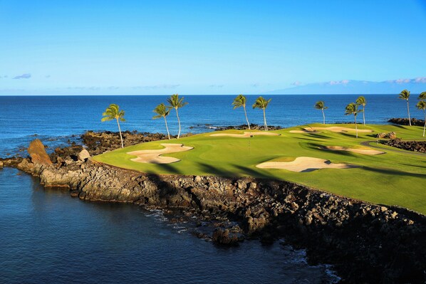 Un parcours de golf situé sur la côte, offrant une vue dégagée sur l’océan et bordé d’une falaise rocheuse.
