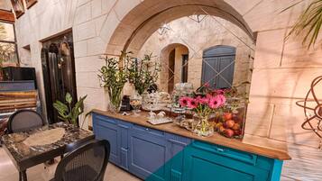 A kitchen with a marble countertop, blue cabinets, and a decorative archway.