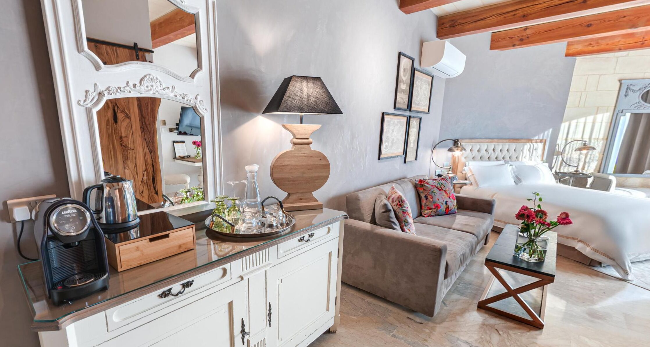 A well-lit living room with a sofa, a coffee table, a cabinet, and a large mirror.