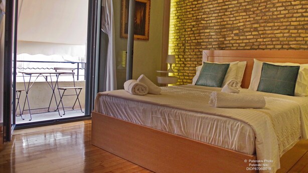 A hotel room with a bed, a table, and a view of the outdoors. - Athens Historic Centre Renovated Apartment (Athina)