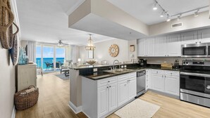 A modern kitchen with white cabinets, stainless steel appliances, and a large island. - Gulf-Front 2 Bed, 2 Bath • Sleeps 8 • Amenity-Packed • Beach Chair Service for 2 (Panama City Beach)