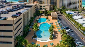 A hotel with a rooftop pool, multiple parking levels, and a view of the ocean. - Gulf-Front 2 Bed, 2 Bath • Sleeps 8 • Amenity-Packed • Beach Chair Service for 2 (Panama City Beach)