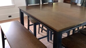 A dining room with a large rectangular table, six chairs, and a bench.