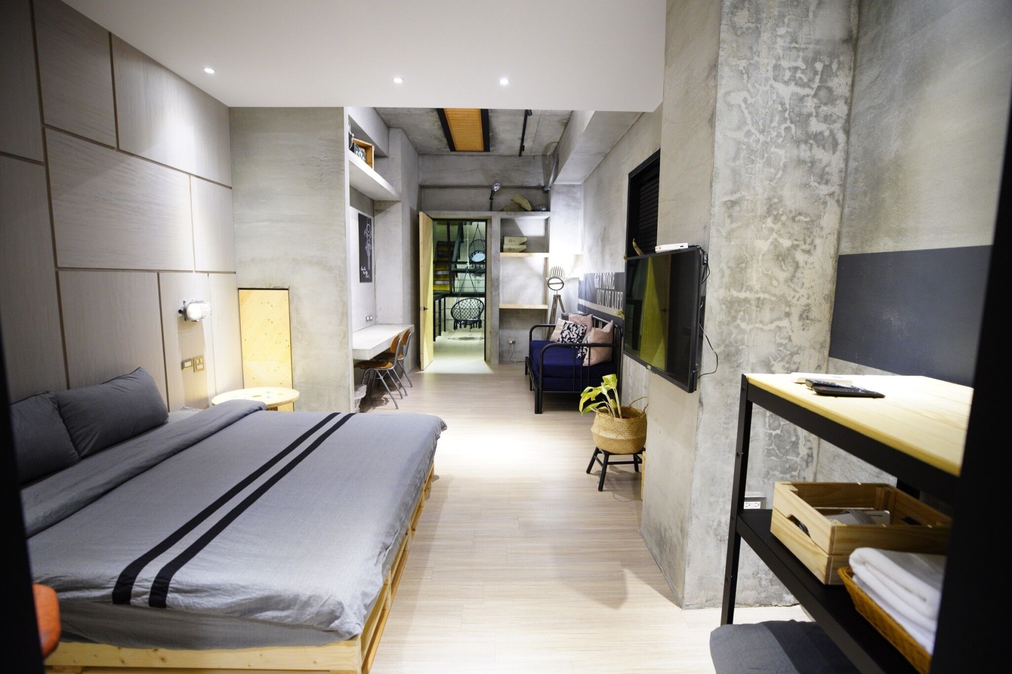 Une chambre moderne avec un grand lit, un bureau et une télévision.