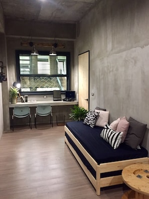 A compact room with a bed, desk, and chairs. - Looft (Hengchun)