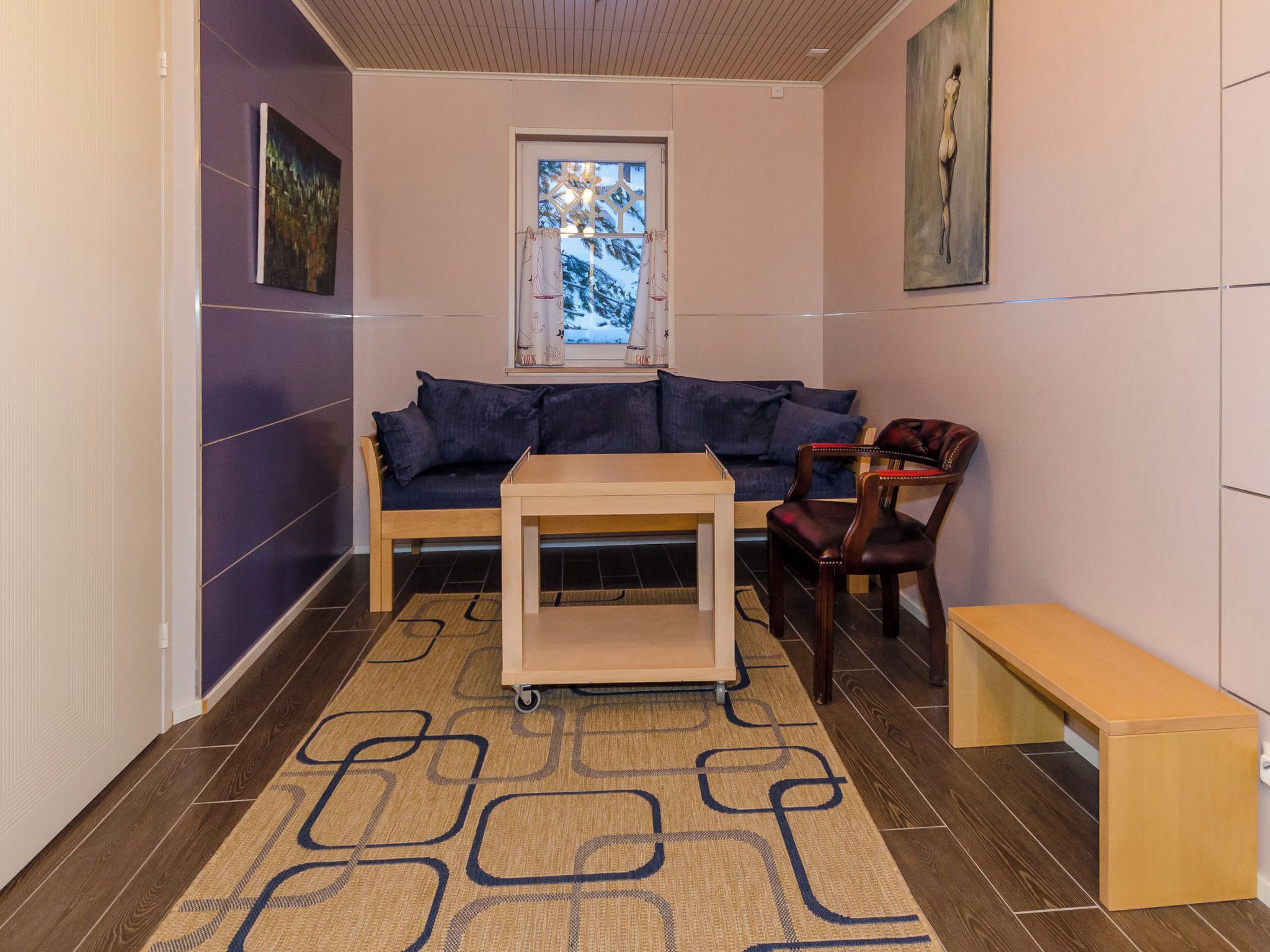 A room with a sofa, a chair, a small table, and a bench.