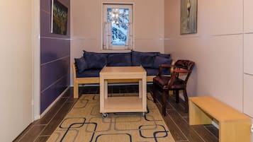 A room with a sofa, a chair, a small table, and a bench.