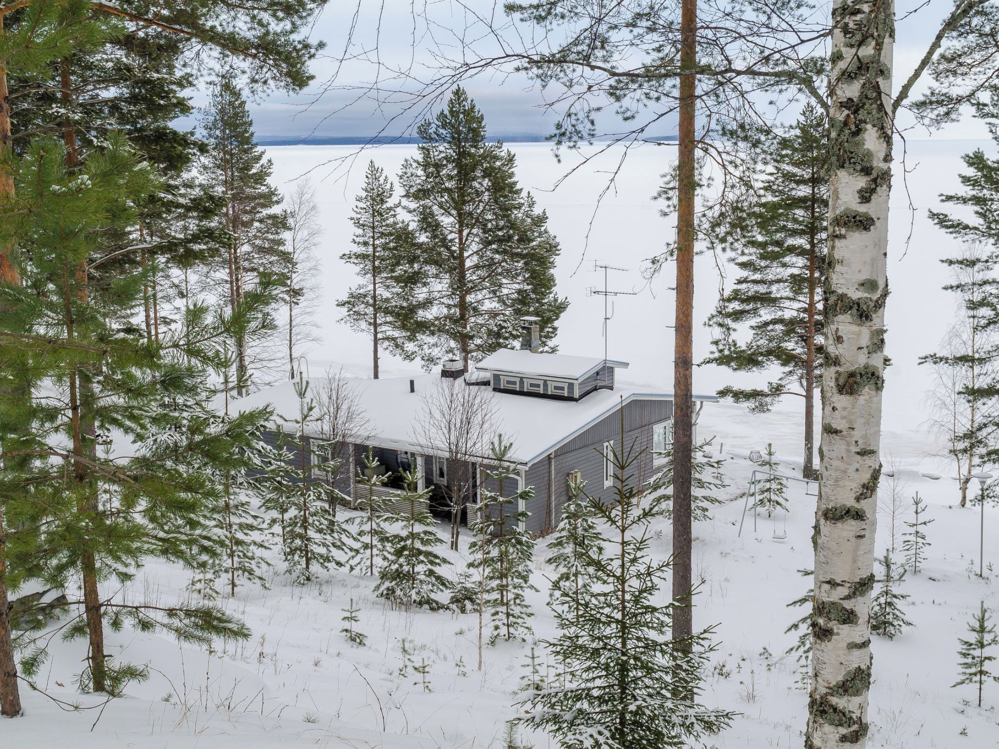 A cabin surrounded by snow-covered trees.