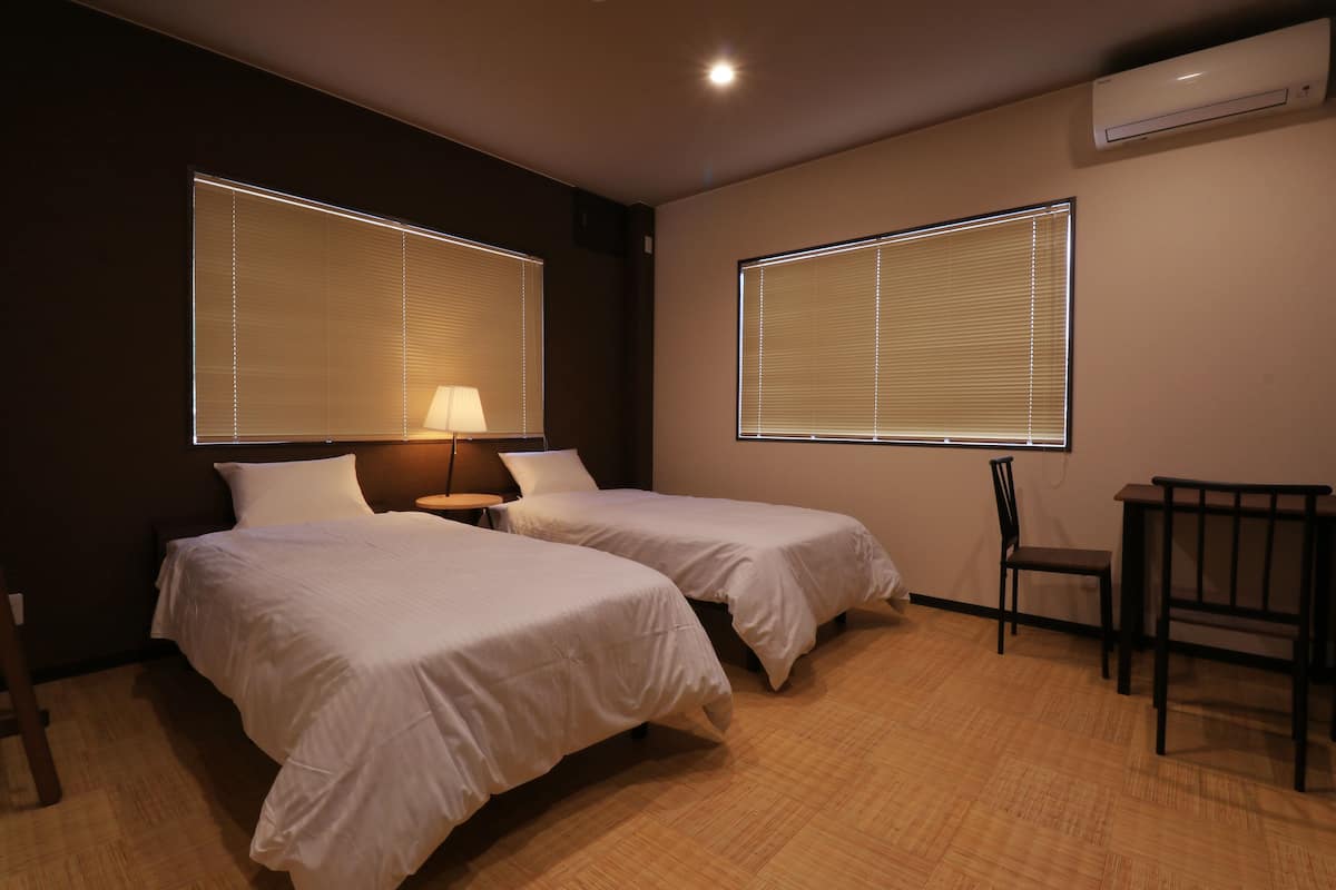 Una habitación de hotel con dos camas, un escritorio y una silla.